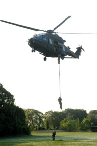 elicottero in volo, militari scendono con la fune