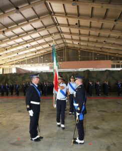 Momento di cambio vertice con bandiera nazionale tra comandante uscente e subentrante
