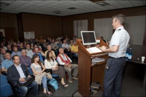 personale AM parla dal pulpito di sala conferenze a gruppo di civili