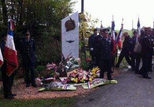 foto di cordoglio di fronte monumento commemorativo defunti con fiori