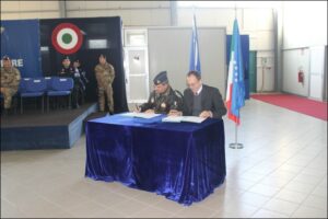 momento di firma, alle spalle del bandiera italiana ed europea