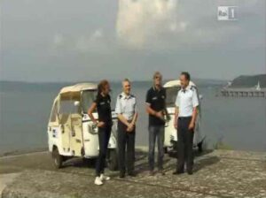 scatto da RAI 1 4 persone di fronte moto ape e sfondo mare