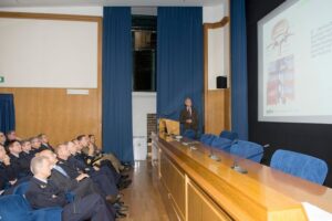 personale AM osserva grande schermo in sala conferenze